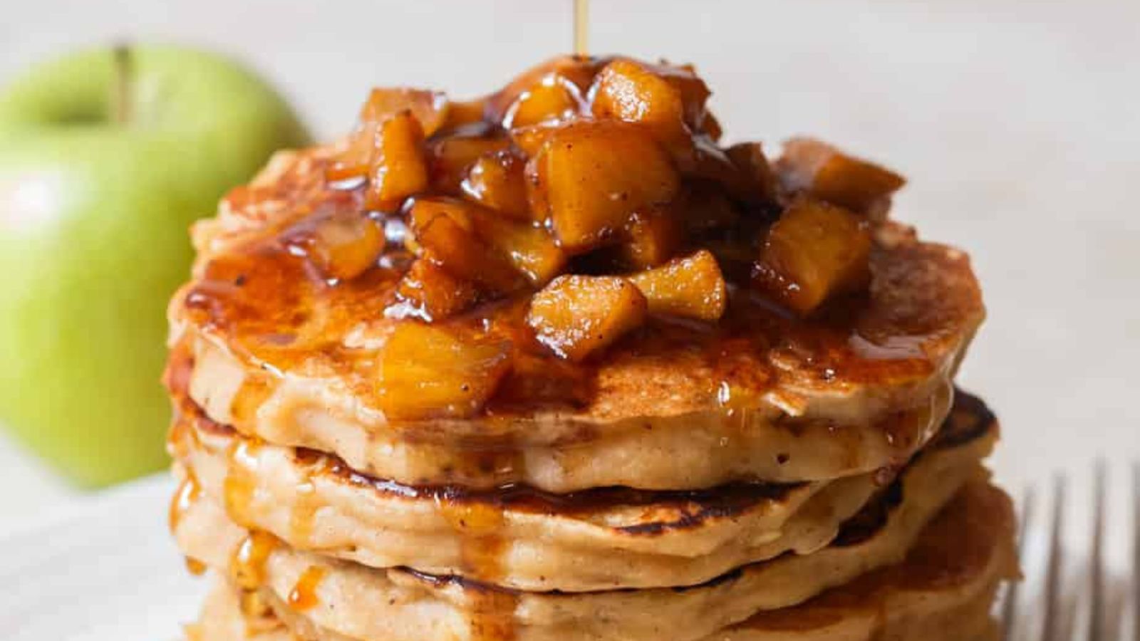 Easy Apple Pancakes stacked up with apples on top.
