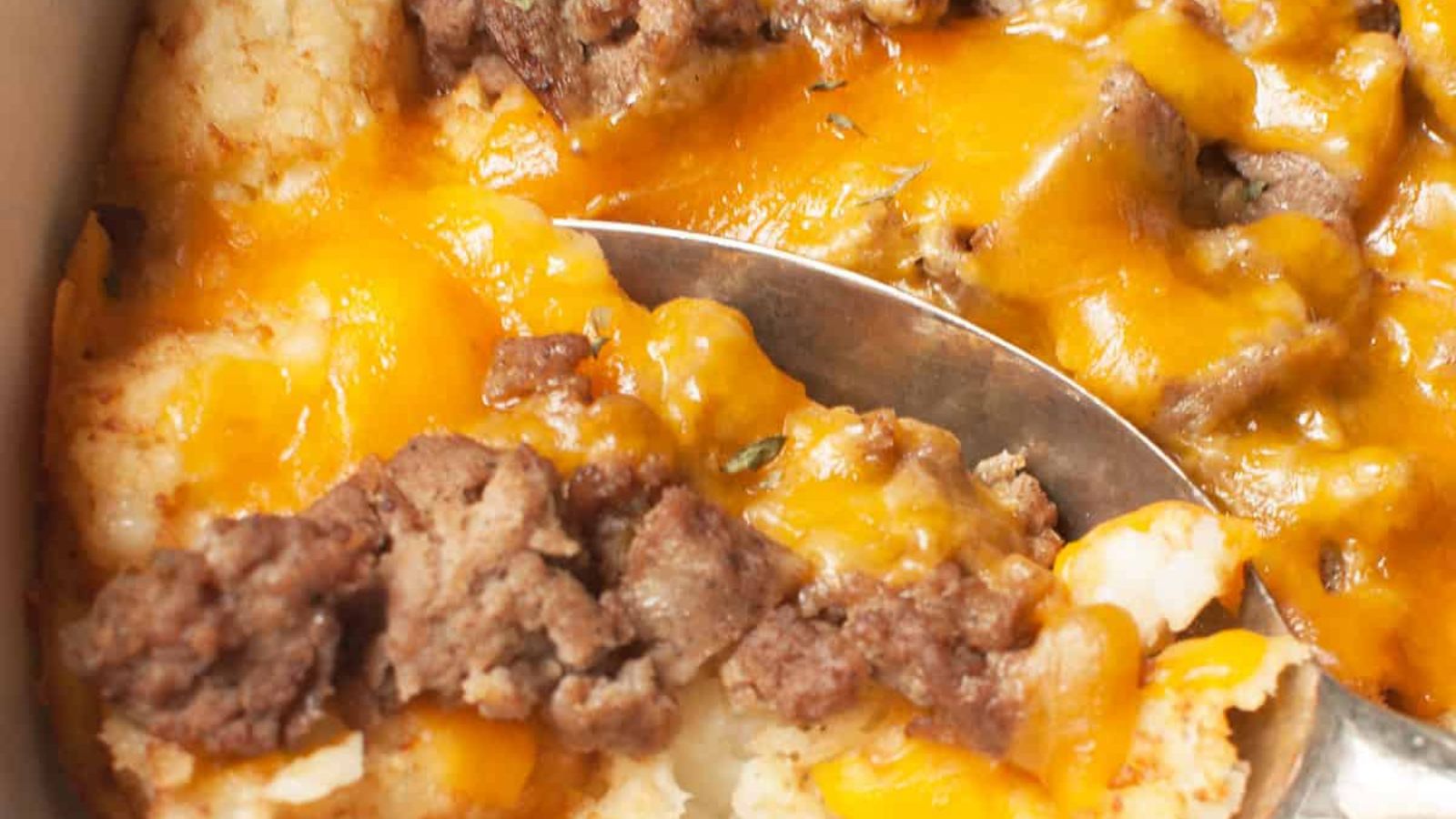 Cheesy Tater Tot Breakfast Bake being dished up with a spoon.