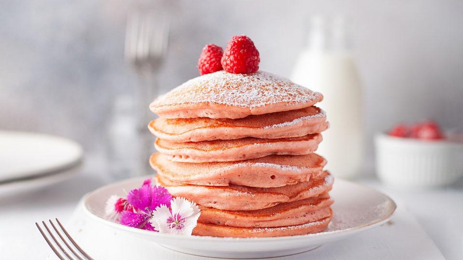 Beetroot Light and Fluffy Pink Pancakes stacked on a white plate.