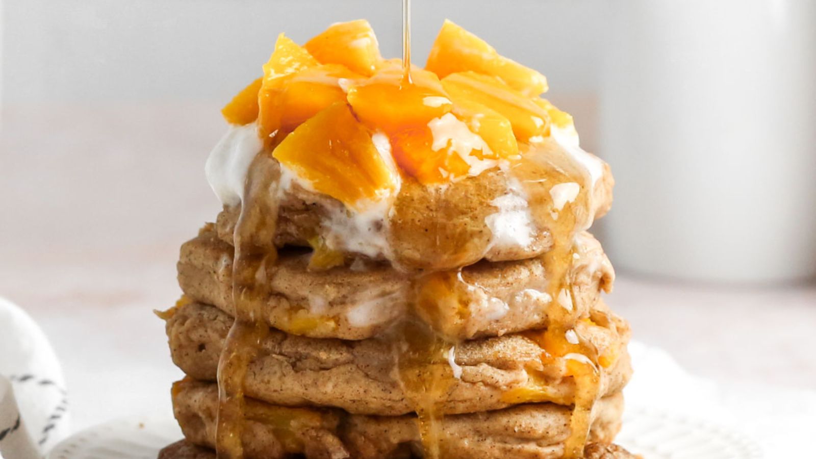 Vegan Peach Cobbler Pancakes stacked up on a plate.
